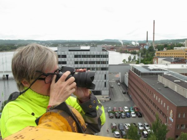 Kvinna högt upp med en kamera