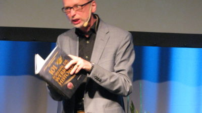 Arg man som håller i en bok