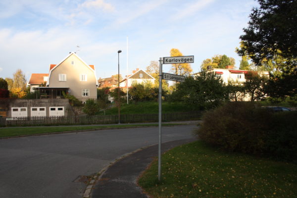 Nutida bild på en väg med ett bostadsområde.
