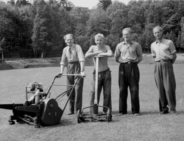 Män som klipper gräset vid Stadsparken