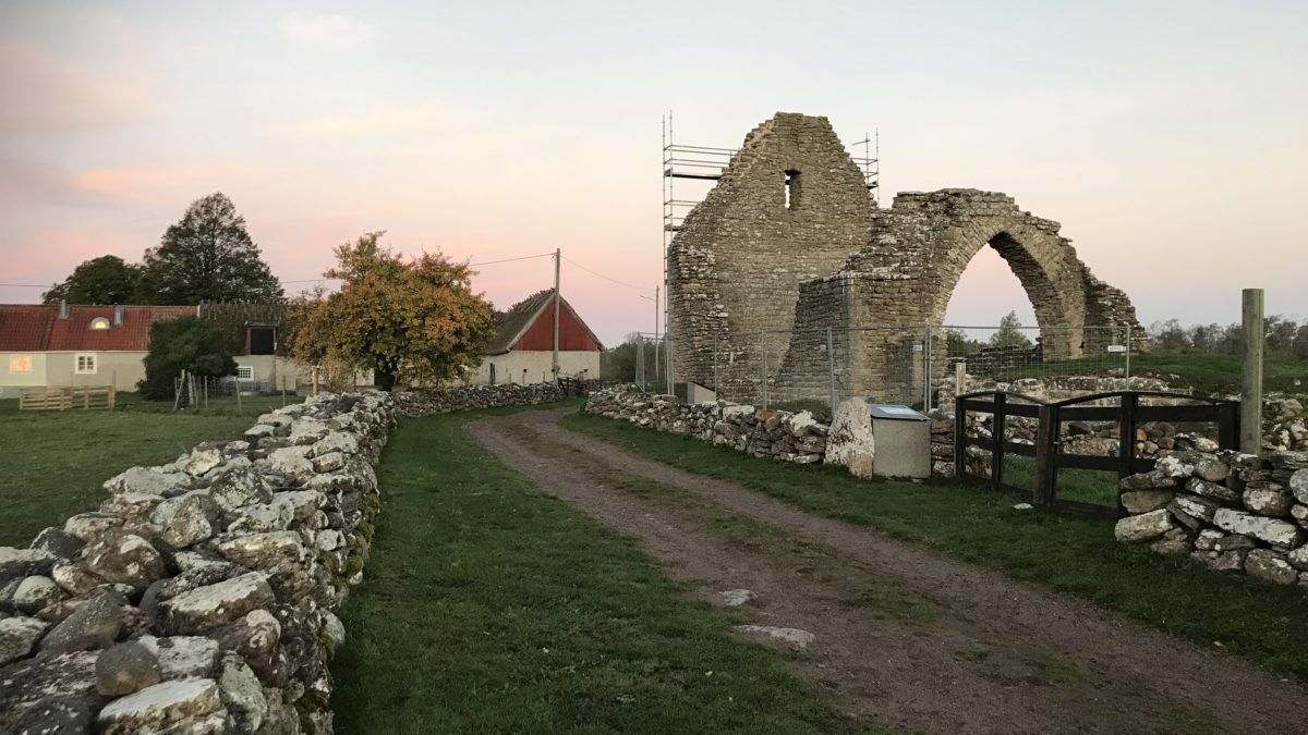 Ruin av en stenbyggnad, en grusväg och en stenmur