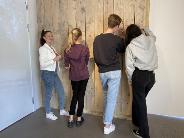 Fyra personer skriver på en vägg