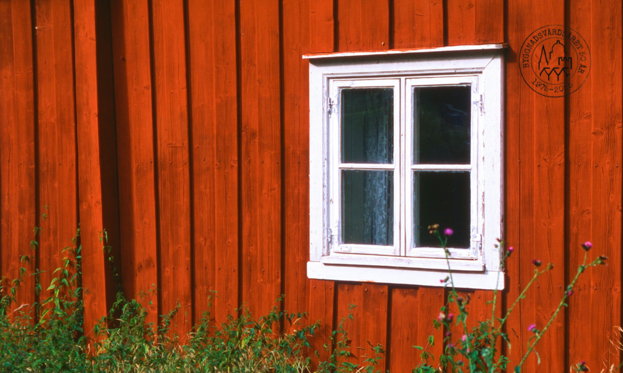 Vitt fönster på rödmålad vägg